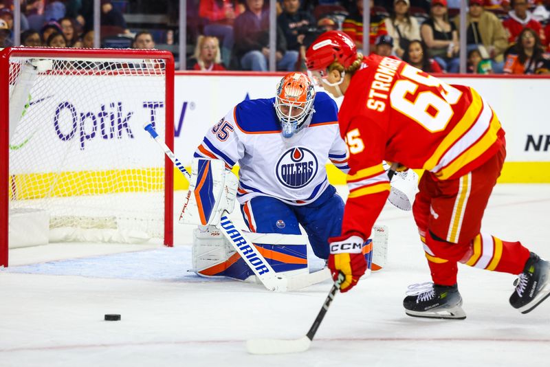 Sep 23, 2024; Calgary, Alberta, CAN; Edmonton Oilers goaltender Olivier Rodrigue (35) guards his net as Calgary Flames left wing William Stromgren (65) tries to score during the second period at Scotiabank Saddledome. Mandatory Credit: Sergei Belski-Imagn Images