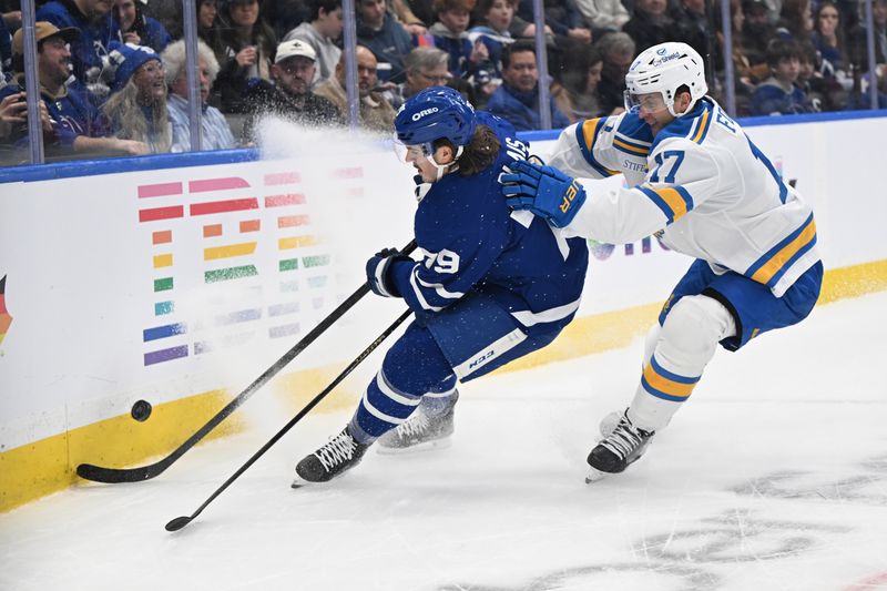 Nov 18, 2025; Toronto, Ontario, CAN;  Toronto Maple Leafs forward Samuel Blais (79) battles for the puck with St. Louis Blues defenseman Cam Fowler (17) in the first period at Scotiabank Arena. Mandatory Credit: Dan Hamilton-Imagn Images