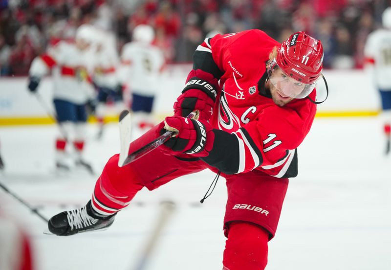 Nov 29, 2024; Raleigh, North Carolina, USA;  Carolina Hurricanes center Jordan Staal (11) takes a shot during the warmups before the game against the Florida Panthers at Lenovo Center. Mandatory Credit: James Guillory-Imagn Images