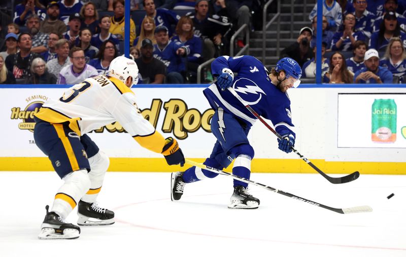 Oct 28, 2024; Tampa, Florida, USA; Tampa Bay Lightning left wing Brandon Hagel (38) shoots as Nashville Predators defenseman Jeremy Lauzon (3) defends during the first period at Amalie Arena. Mandatory Credit: Kim Klement Neitzel-Imagn Images