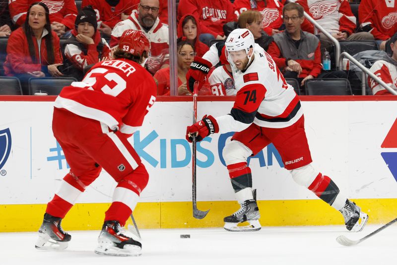 Jan 12, 2026; Detroit, Michigan, USA;  Carolina Hurricanes defenseman Jaccob Slavin (74) skates with the puck defended by Detroit Red Wings defenseman Moritz Seider (53) in the first period at Little Caesars Arena. Mandatory Credit: Rick Osentoski-Imagn Images