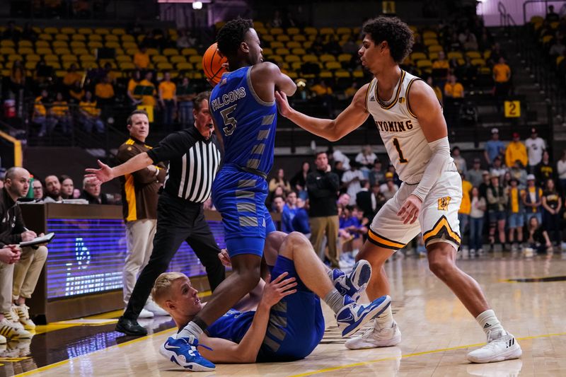 Feb 17, 2023; Laramie, Wyoming, USA; Air Force Falcons guard Ethan Taylor (5) stands over teammate Rytis Petraitis (31) while defended by Wyoming Cowboys guard Brendan Wenzel (1) during the first half at Arena-Auditorium. Mandatory Credit: Troy Babbitt-USA TODAY Sports