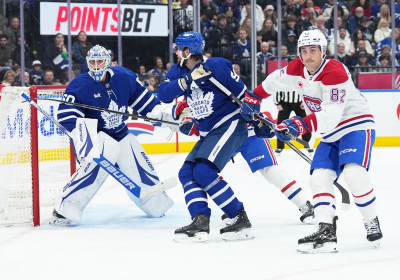 Nov 9, 2024; Toronto, Ontario, CAN; Montreal Canadiens left wing Lucas Condotta (82) battles with Toronto Maple Leafs defenseman Oliver Ekman-Larsson (95) in front of  goaltender Joseph Woll (60) during the second period at Scotiabank Arena. Mandatory Credit: Nick Turchiaro-Imagn Images