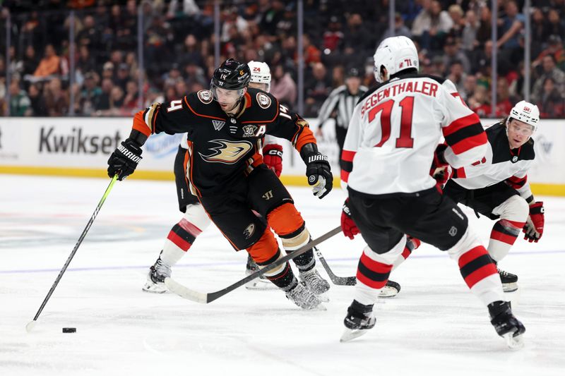 Mar 1, 2024; Anaheim, California, USA; Anaheim Ducks center Adam Henrique (14) controls the puck against New Jersey Devils defenseman Jonas Siegenthaler (71) during the second period at Honda Center. Mandatory Credit: Kiyoshi Mio-USA TODAY Sports