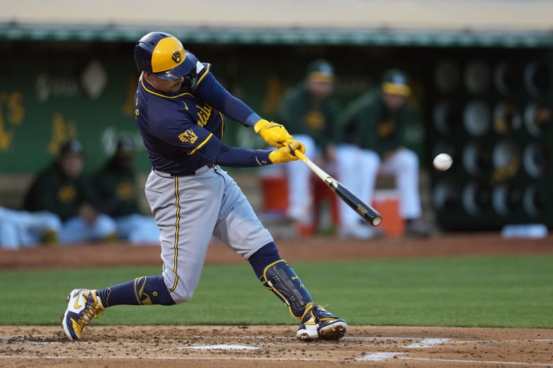 Aug 23, 2024; Oakland, California, USA; Milwaukee Brewers first baseman Rhys Hoskins (12) hits a home run against the Oakland Athletics during the second inning at Oakland-Alameda County Coliseum. Mandatory Credit: Darren Yamashita-USA TODAY Sports