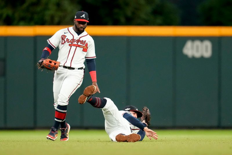 Oct 12, 2022; Atlanta, Georgia, USA; Atlanta Braves shortstop Dansby Swanson (right) dives to make a catch on a fly ball as center fielder Michael Harris II (23) supports in the game against the Philadelphia Phillies in the sixth inning during game two of the NLDS for the 2022 MLB Playoffs at Truist Park. Mandatory Credit: Dale Zanine-USA TODAY Sports