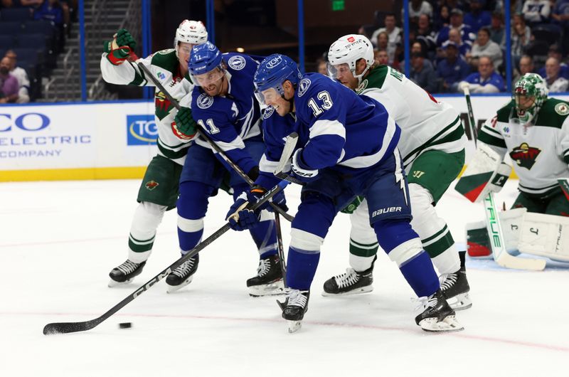 Oct 24, 2024; Tampa, Florida, USA;Tampa Bay Lightning right wing Cameron Atkinson (13) and center Luke Glendening (11) fight to control the puck as Minnesota Wild defenseman Jon Merrill (4) and defenseman Declan Chisholm (47) defend during the first period at Amalie Arena. Mandatory Credit: Kim Klement Neitzel-Imagn Images