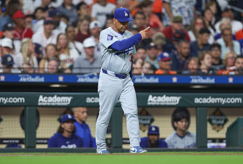 Jul 27, 2024; Houston, Texas, USA; Los Angeles Dodgers manager Dave Roberts (30) motions for a pitching change during the sixth inning against the Houston Astros at Minute Maid Park. Mandatory Credit: Troy Taormina-USA TODAY Sports