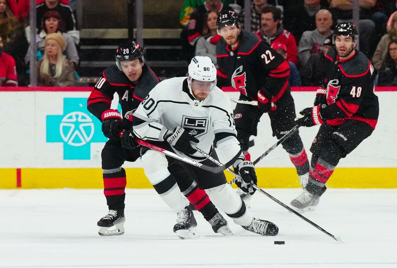 Jan 15, 2024; Raleigh, North Carolina, USA; Los Angeles Kings center Pierre-Luc Dubois (80) is checked by Carolina Hurricanes center Sebastian Aho (20) during the first period at PNC Arena. Mandatory Credit: James Guillory-USA TODAY Sports