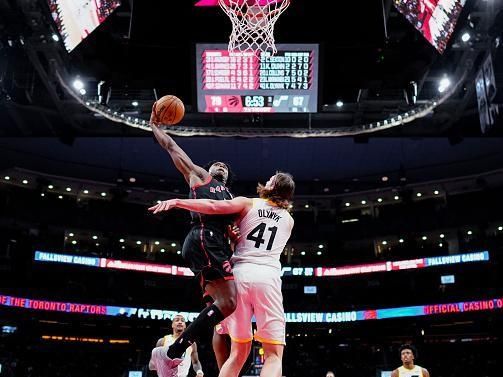 TORONTO, ON - DECEMBER 23: OG Anunoby #3 of the Toronto Raptors goes to the basket against Kelly Olynyk #41 of the Utah Jazz during the second half of their basketball game at the Scotiabank Arena on December 23, 2023 in Toronto, Ontario, Canada. NOTE TO USER: User expressly acknowledges and agrees that, by downloading and/or using this Photograph, user is consenting to the terms and conditions of the Getty Images License Agreement. (Photo by Mark Blinch/Getty Images)