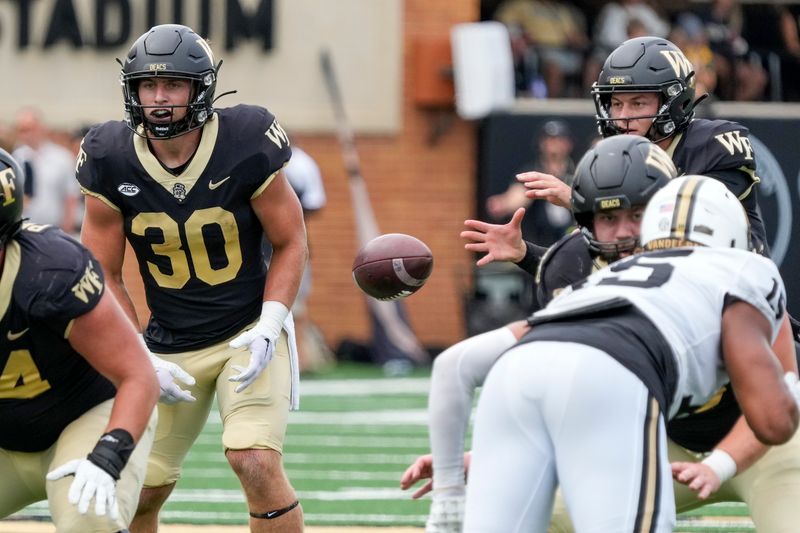 Sep 9, 2023; Winston-Salem, North Carolina, USA; Wake Forest Demon Deacons running back Tate Carney (30) watches the snap to quarterback Mitch Griffis (12) during the second quarter against the Vanderbilt Commodores at Allegacy Federal Credit Union Stadium. Mandatory Credit: Jim Dedmon-USA TODAY Sports