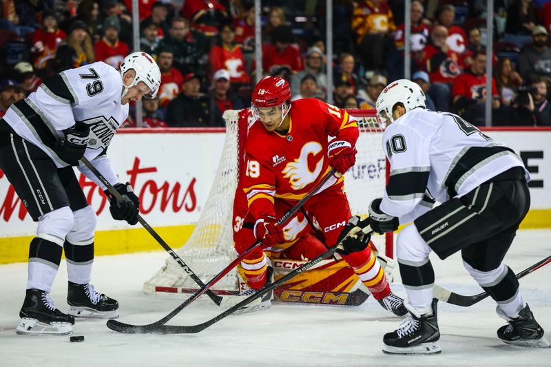 Mar 24, 2026; Calgary, Alberta, CAN; Calgary Flames defenseman Zayne Parekh (19) defends against Los Angeles Kings center Samuel Helenius (79) and right wing Joel Armia (40) during the first period at Scotiabank Saddledome. Mandatory Credit: Sergei Belski-Imagn Images