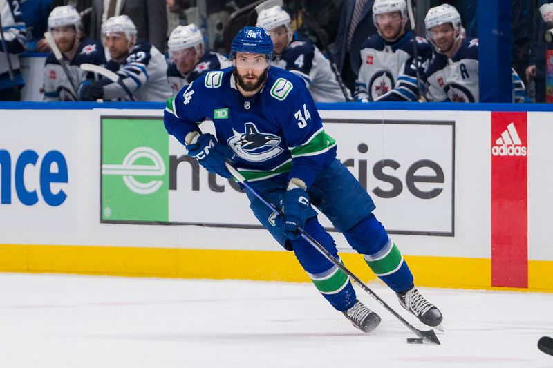 Mar 9, 2024; Vancouver, British Columbia, CAN; Vancouver Canucks forward Phillip Di Giuseppe (34) handles the puck against the Winnipeg Jets in the second period at Rogers Arena. Mandatory Credit: Bob Frid-USA TODAY Sports