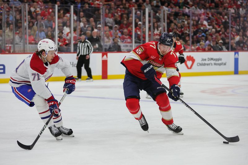 Feb 29, 2024; Sunrise, Florida, USA; Florida Panthers defenseman Niko Mikkola (77) moves the puck against Montreal Canadiens center Jake Evans (71) during the second period at Amerant Bank Arena. Mandatory Credit: Sam Navarro-USA TODAY Sports