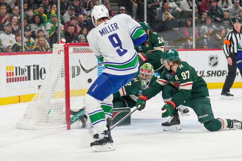 Feb 19, 2024; Saint Paul, Minnesota, USA; Vancouver Canucks center J.T. Miller (9) shoots and scores as Minnesota Wild goaltender Filip Gustavsson (32) and left wing Kirill Kaprizov (97) defend in the first period at Xcel Energy Center. Mandatory Credit: Matt Blewett-USA TODAY Sports