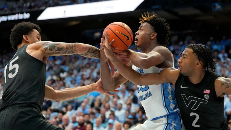 Feb 17, 2024; Chapel Hill, North Carolina, USA; North Carolina Tar Heels forward Harrison Ingram (55) with the ball as Virginia Tech Hokies center Lynn Kidd (15) and guard MJ Collins (2) defend in the second half at Dean E. Smith Center. Mandatory Credit: Bob Donnan-USA TODAY Sports