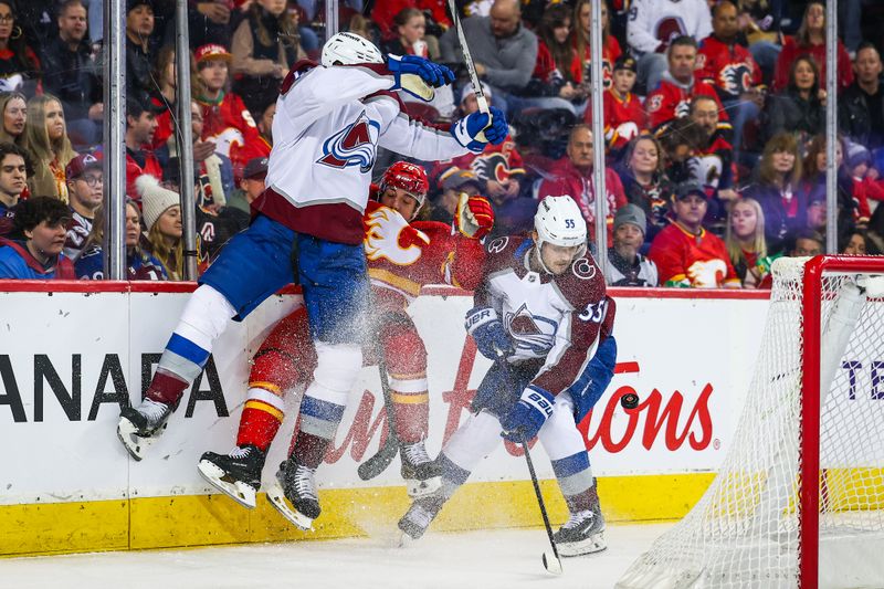 Mar 14, 2025; Calgary, Alberta, CAN; Colorado Avalanche defenseman Josh Manson (42) checks into the boards Calgary Flames left wing Ryan Lomberg (70) during the second period at Scotiabank Saddledome. Mandatory Credit: Sergei Belski-Imagn Images