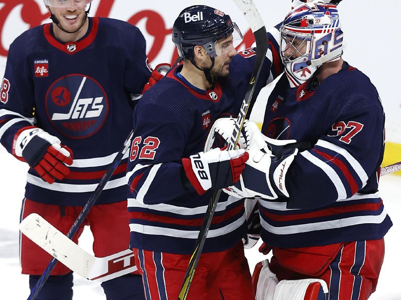 Apr 2, 2023; Winnipeg, Manitoba, CAN;  Winnipeg Jets defenseman Nate Schmidt (88), Winnipeg Jets right wing Nino Niederreiter (62) and Winnipeg Jets goaltender Connor Hellebuyck (37) celebrate their victory over the New Jersey Devils at Canada Life Centre. Mandatory Credit: James Carey Lauder-USA TODAY Sports