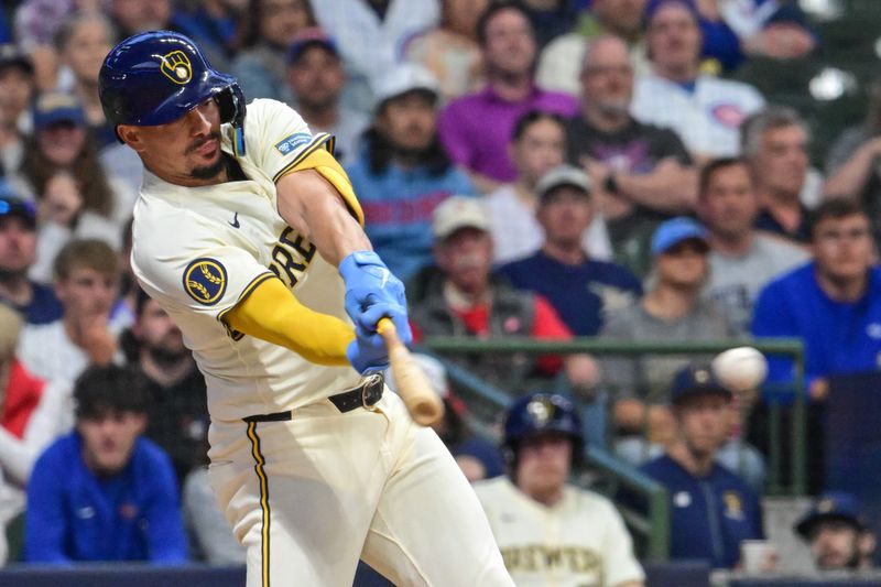 May 29, 2024; Milwaukee, Wisconsin, USA; Milwaukee Brewers shortstop Willy Adames (27) hits a single to drive in a run in the third inning against the Chicago Cubs at American Family Field. Mandatory Credit: Benny Sieu-USA TODAY Sports