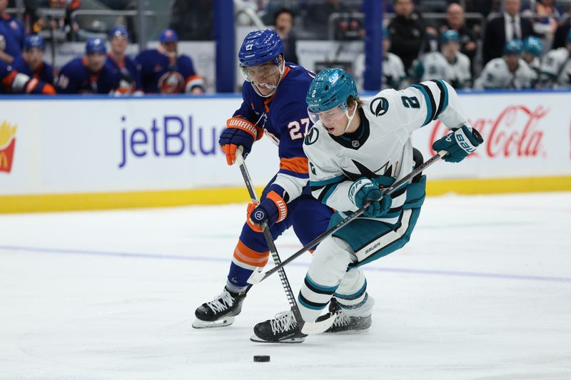 Jan 18, 2025; Elmont, New York, USA;  San Jose Sharks center Will Smith (2) controls the puck as New York Islanders left wing Anders Lee (27) defends during the third period at UBS Arena. Mandatory Credit: Thomas Salus-Imagn Images