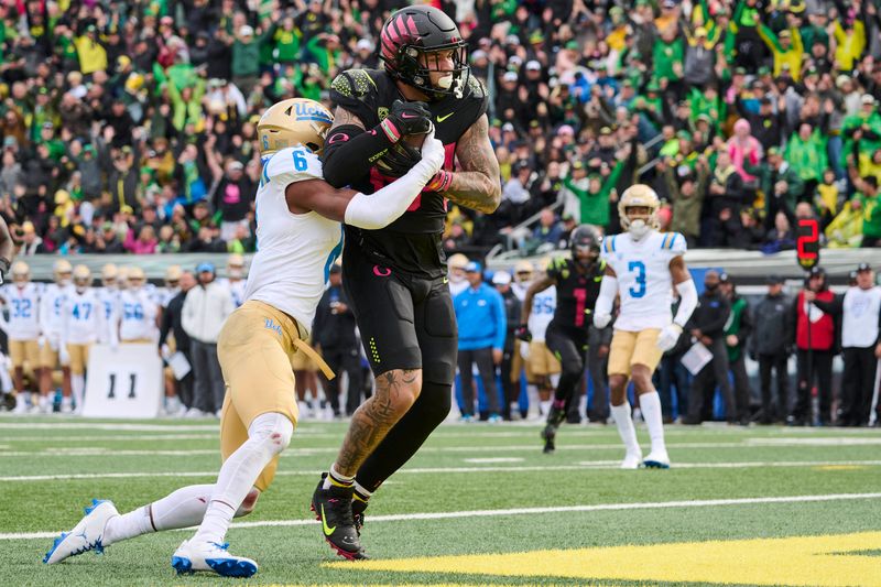 Oct 22, 2022; Eugene, Oregon, USA; Oregon Ducks tight end Cam McCormick (84) catches a touchdown pass during the second half against UCLA Bruins defensive back John Humphrey (6) at Autzen Stadium. The Ducks won the game 45-30. Mandatory Credit: Troy Wayrynen-USA TODAY Sports