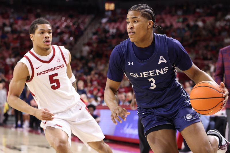 Dec 16, 2025; Fayetteville, Arkansas, USA; Queens Royals guard Isaiah Henry (3) drives against Arkansas Razorbacks guard Darius Acuff Jr (5) during the first half at Bud Walton Arena. Mandatory Credit: Nelson Chenault-Imagn Images
