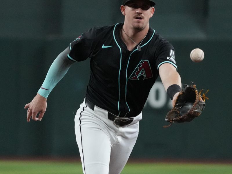 Aug 9, 2024; Phoenix, Arizona, USA; Arizona Diamondbacks first baseman Kevin Newman (18) flips the ball for an out against the Philadelphia Phillies in the first inning at Chase Field. Mandatory Credit: Rick Scuteri-USA TODAY Sports