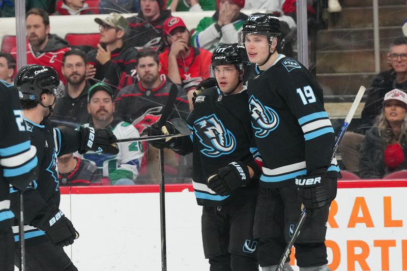 Jan 29, 2026; Raleigh, North Carolina, USA;  Utah Mammoth right wing JJ Peterka (77) is congratulated by left wing Daniil But (19) after scoring against the Carolina Hurricanes during the second period  at Lenovo Center. Mandatory Credit: James Guillory-Imagn Images