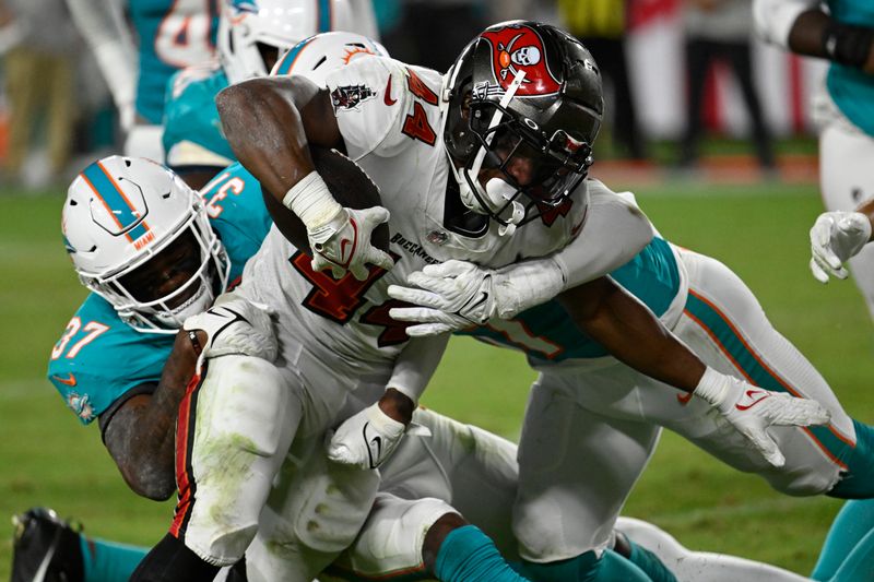 Miami Dolphins cornerback Isaiah Johnson (37) stops Tampa Bay Buccaneers running back Sean Tucker (44) near the goal line during the second half of a pre season NFL football game, Friday, Aug. 23, 2024, in Tampa, Fla. (AP Photo/Jason Behnken)