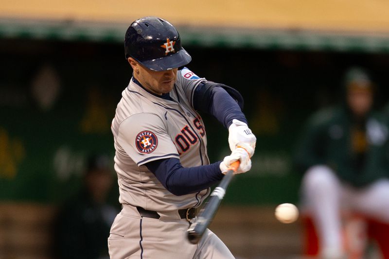 May 24, 2024; Oakland, California, USA; Houston Astros third baseman Alex Bregman (2) connects for a single against the Oakland Athletics during the fourth inning at Oakland-Alameda County Coliseum. Mandatory Credit: D. Ross Cameron-USA TODAY Sports