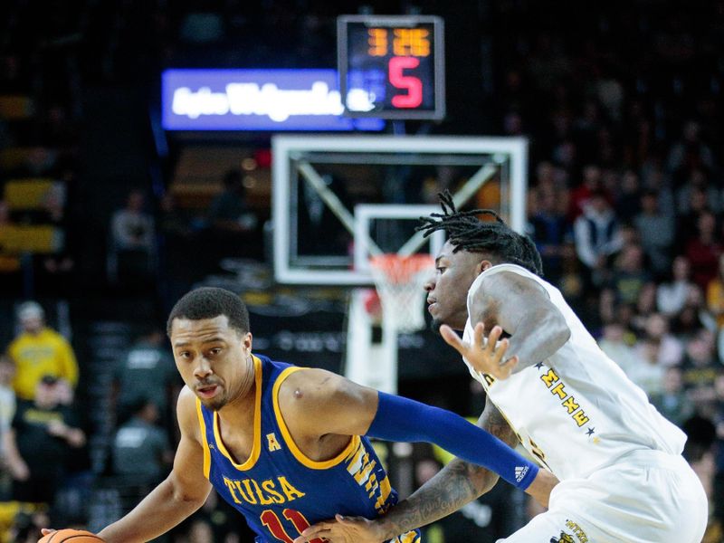 Jan 14, 2023; Wichita, Kansas, USA; Tulsa Golden Hurricane guard Brandon Betson (11) drives around Wichita State Shockers guard Jaron Pierre Jr. (5) during the first half at Charles Koch Arena. Mandatory Credit: William Purnell-USA TODAY Sports