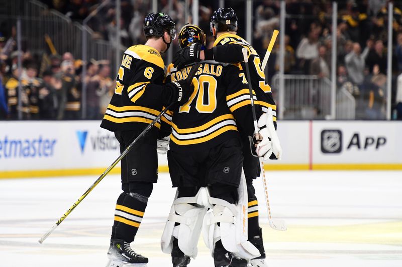 Nov 7, 2024; Boston, Massachusetts, USA;  Boston Bruins defenseman Mason Lohrei (6) and defenseman Nikita Zadorov (91) celebrate with goaltender Joonas Korpisalo (70) after defeating the Calgary Flames in overtime at TD Garden. Mandatory Credit: Bob DeChiara-Imagn Images