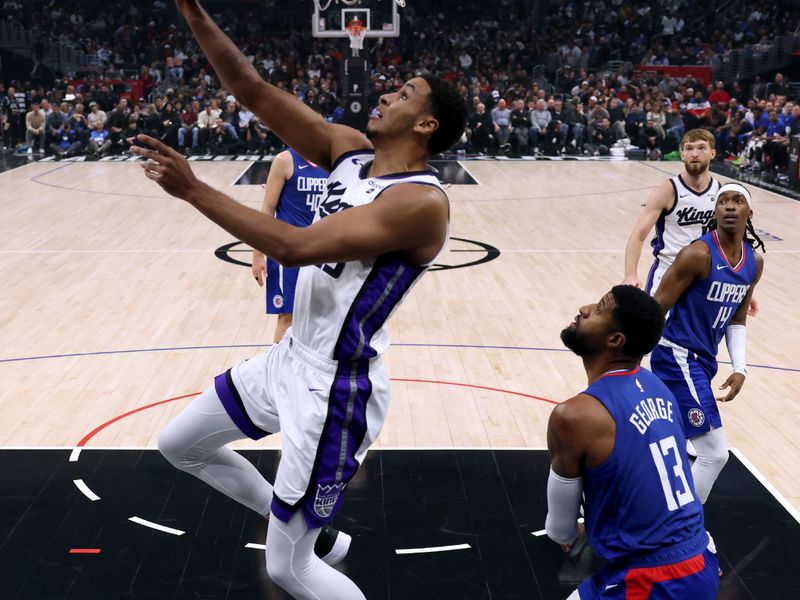 LOS ANGELES, CALIFORNIA - DECEMBER 12: Keegan Murray #13 of the Sacramento Kings scores on a reverse layup in front of Paul George #13 of the LA Clippers during a 119-99 Clippers win at Crypto.com Arena on December 12, 2023 in Los Angeles, California.  NOTE TO USER: User expressly acknowledges and agrees that, by downloading and or using this photograph, User is consenting to the terms and conditions of the Getty Images License Agreement. (Photo by Harry How/Getty Images)