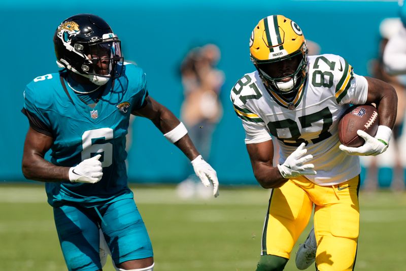 Green Bay Packers' Romeo Doubs catches a pass in front of Jacksonville Jaguars' Darnell Savage during the first half of an NFL football game Sunday, Oct. 27, 2024, in Jacksonville, Fla. (AP Photo/John Bazemore)