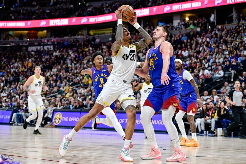 DENVER, COLORADO - MARCH 9: John Collins #20 of the Utah Jazz drives against Nikola Jokic #15 of the Denver Nuggets before scoring in the second half of a game at Ball Arena on March 9, 2024 in Denver, Colorado. (Photo by Dustin Bradford/Getty Images)