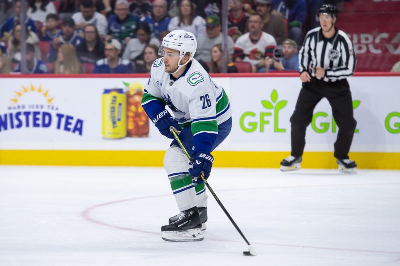 Nov 23, 2024; Ottawa, Ontario, CAN; Vancouver Canucks defenseman Erik Brannstrom (26) skates with the puck during warmup prior to game against the Ottawa Senators at the Canadian Tire Centre. Mandatory Credit: Marc DesRosiers-Imagn Images