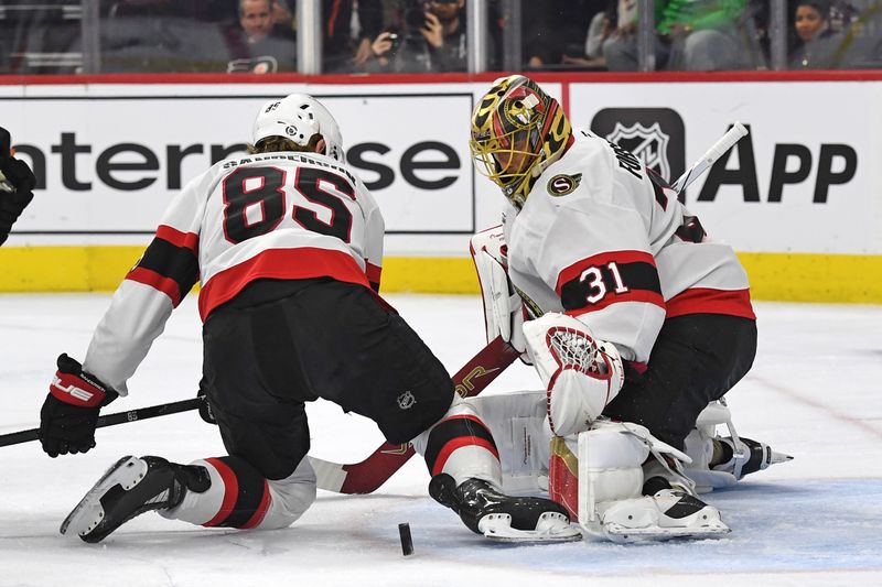 Mar 11, 2025; Philadelphia, Pennsylvania, USA; Ottawa Senators defenseman Jake Sanderson (85) and goaltender Anton Forsberg (31) cover the puck against the Philadelphia Flyers  during the first period at Wells Fargo Center. Mandatory Credit: Eric Hartline-Imagn Images