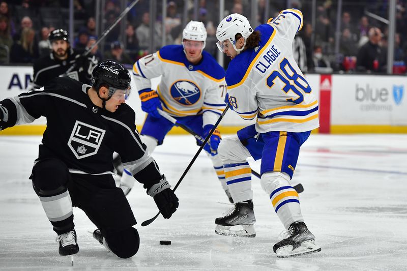 Feb 13, 2023; Los Angeles, California, USA; Buffalo Sabres defenseman Kale Clague (38) moves the puck against Los Angeles Kings left wing Trevor Moore (12) during the third period at Crypto.com Arena. Mandatory Credit: Gary A. Vasquez-USA TODAY Sports