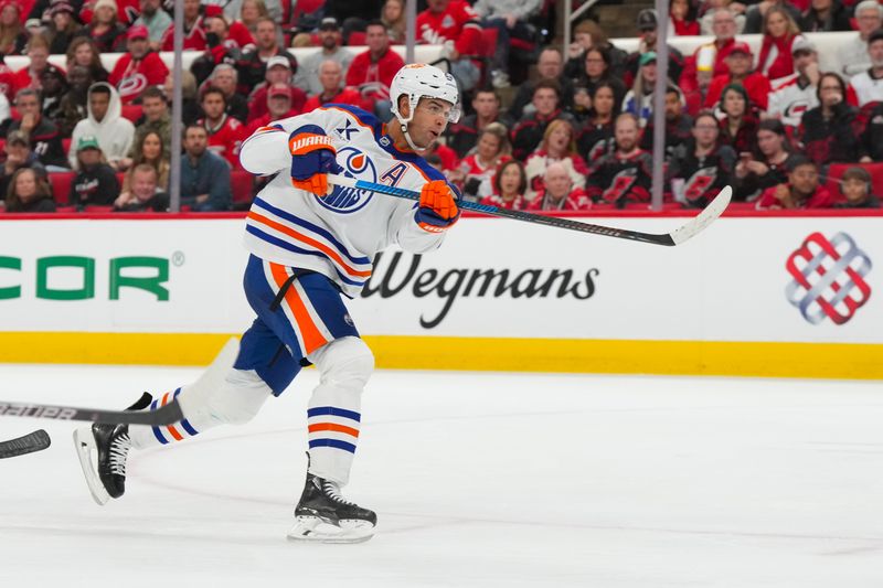 Nov 15, 2025; Raleigh, North Carolina, USA;  Edmonton Oilers defenseman Darnell Nurse (25) takes a shot against the Carolina Hurricanes during the second period at Lenovo Center. Mandatory Credit: James Guillory-Imagn Images