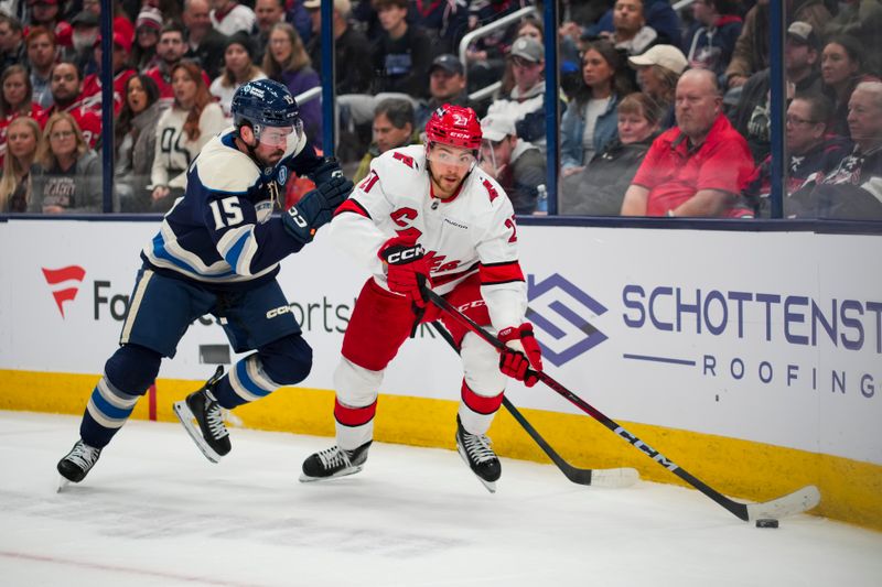 Nov 23, 2024; Columbus, Ohio, USA;  Carolina Hurricanes center Tyson Jost (27) skates with the puck against Columbus Blue Jackets defenseman Dante Fabbro (15) in the first period at Nationwide Arena. Mandatory Credit: Aaron Doster-Imagn Images