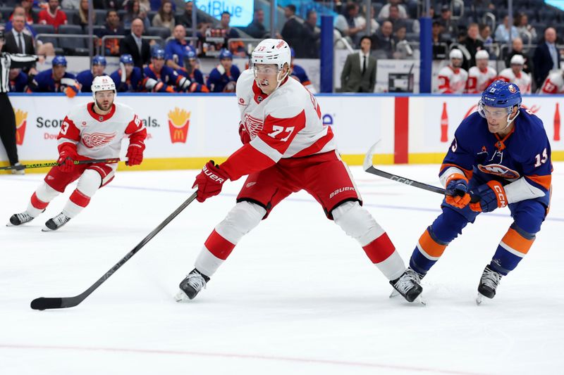 Oct 22, 2024; Elmont, New York, USA; Detroit Red Wings defenseman Simon Edvinsson (77) skates with the puck against New York Islanders center Mathew Barzal (13) during the first period at UBS Arena. Mandatory Credit: Brad Penner-Imagn Images