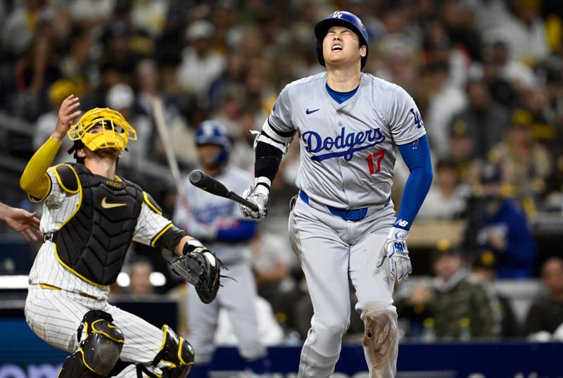 Oct 9, 2024; San Diego, California, USA; Los Angeles Dodgers designated hitter Shohei Ohtani (17) reacts after being hit with a foul ball  in the eighth inning against the San Diego Padres during game four of the NLDS for the 2024 MLB Playoffs at Petco Park.  Mandatory Credit: Denis Poroy-Imagn Images