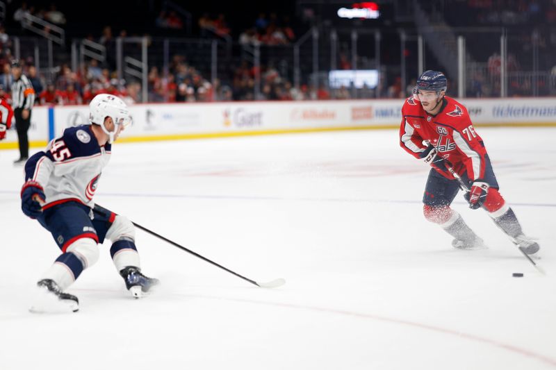 Sep 27, 2024; Washington, District of Columbia, USA; Washington Capitals defenseman Nicky Leivermann (76) skates with the puck as Columbus Blue Jackets center Gavin Brindley (45) defends in the third period at Capital One Arena. Mandatory Credit: Geoff Burke-Imagn Images