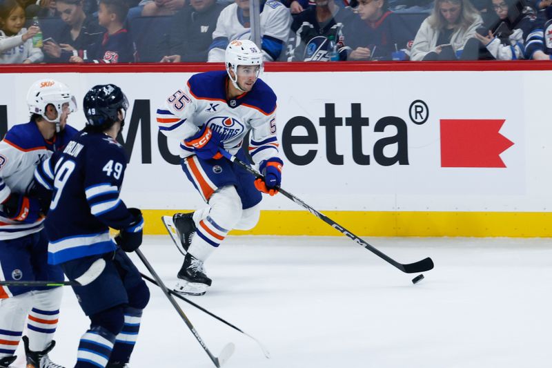 Sep 23, 2025; Winnipeg, Manitoba, CAN;  Edmonton Oilers defenseman Cam Dineen (55) skates away from Winnipeg Jets forward Colby Barlow (49) during the third period at Canada Life Centre. Mandatory Credit: Terrence Lee-Imagn Images