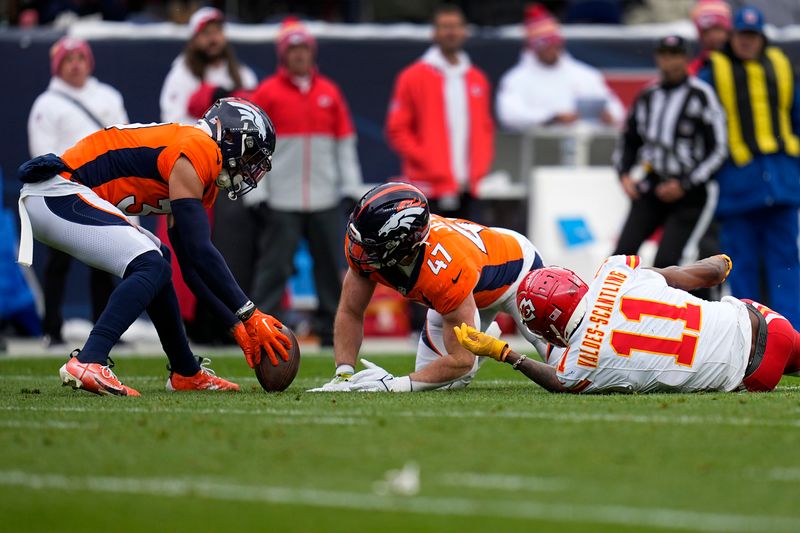 Denver Broncos safety Justin Simmons, left, recovers a fumble by Kansas City Chiefs wide receiver Marquez Valdes-Scantling (11) as Broncos inside linebacker Josey Jewell (47) watches during the first half of an NFL football game Sunday, Oct. 29, 2023, in Denver. (AP Photo/Jack Dempsey)