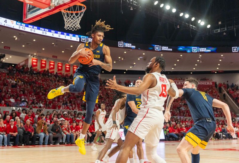 Jan 6, 2024; Houston, Texas, USA; West Virginia Mountaineers guard Noah Farrakhan (1) grabs a defensive rebound against Houston Cougars forward J'Wan Roberts (13) in the first half at Fertitta Center. Mandatory Credit: Thomas Shea-USA TODAY Sports