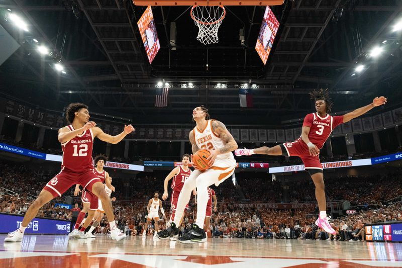 Feb 18, 2023; Austin, Texas, USA; Texas Longhorns forward Christian Bishop (32) drives to the basket between Oklahoma Sooners guards Milos Uzan (12) and Otega Oweh (3) during the second half at Moody Center. Mandatory Credit: Scott Wachter-USA TODAY Sports