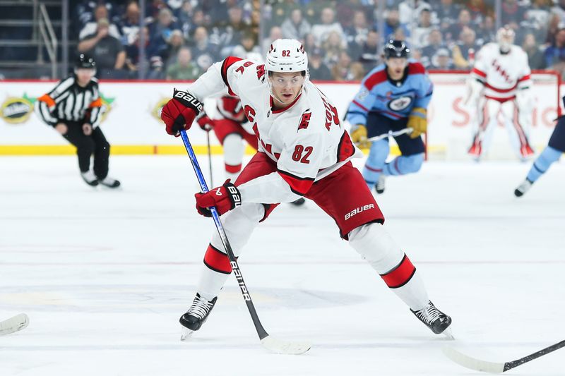 Dec 4, 2023; Winnipeg, Manitoba, CAN;   Carolina Hurricanes forward Jesperi Kotkaniemi (82) skates into the Winnipeg Jets zone during the first period at Canada Life Centre. Mandatory Credit: Terrence Lee-USA TODAY Sports