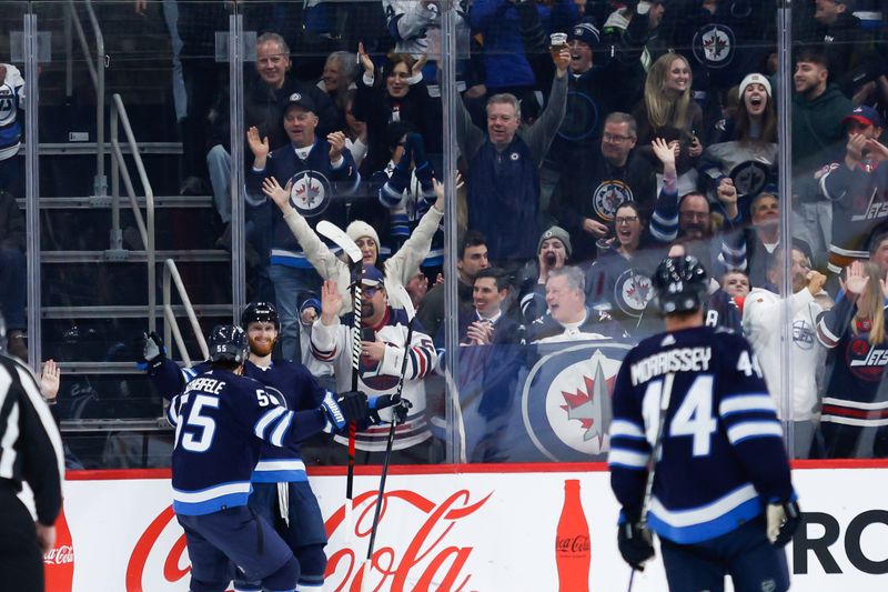 Feb 27, 2024; Winnipeg, Manitoba, CAN; Winnipeg Jets forward Kyle Connor (81) is congratulated by his team mates on his goal against the St. Louis Blues during the first period at Canada Life Centre. Mandatory Credit: Terrence Lee-USA TODAY Sports