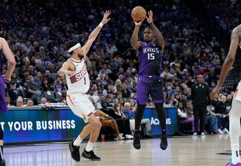 SACRAMENTO, CALIFORNIA - APRIL 12: Davion Mitchell #15 of the Sacramento Kings shoots over Devin Booker #1 of the Phoenix Suns during the second half of an NBA basketball game at Golden 1 Center on April 12, 2024 in Sacramento, California. NOTE TO USER: User expressly acknowledges and agrees that, by downloading and or using this photograph, User is consenting to the terms and conditions of the Getty Images License Agreement. (Photo by Thearon W. Henderson/Getty Images)